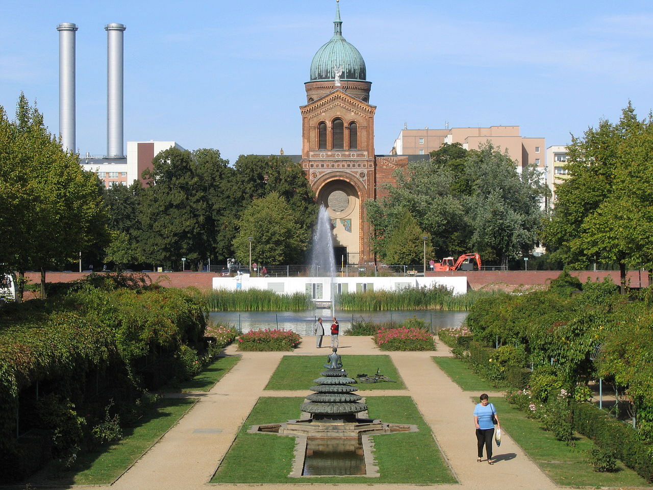 A large domed church visible beyond a garden and a canal.