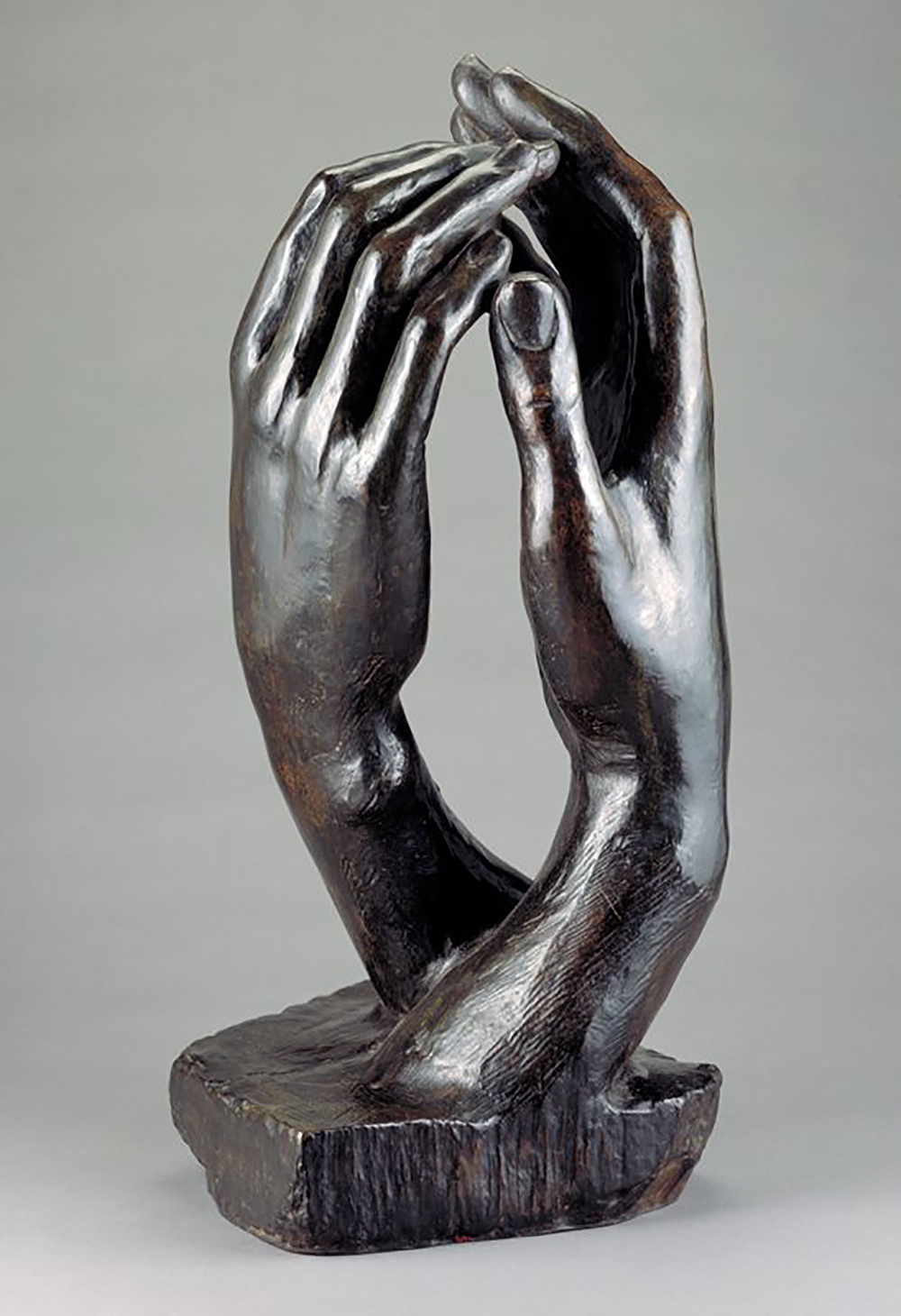 Bronze sculpture of two facing hands with fingertips touching