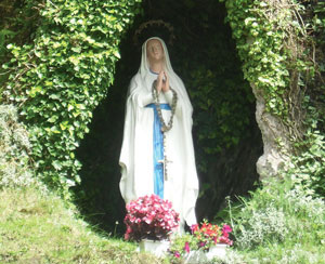 A Virgin Mary statue in a garden.