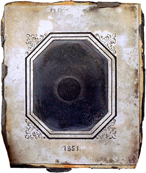 A small black-and-white image of a solar eclipse in a white paper frame. On the frame, someone has written 1851.