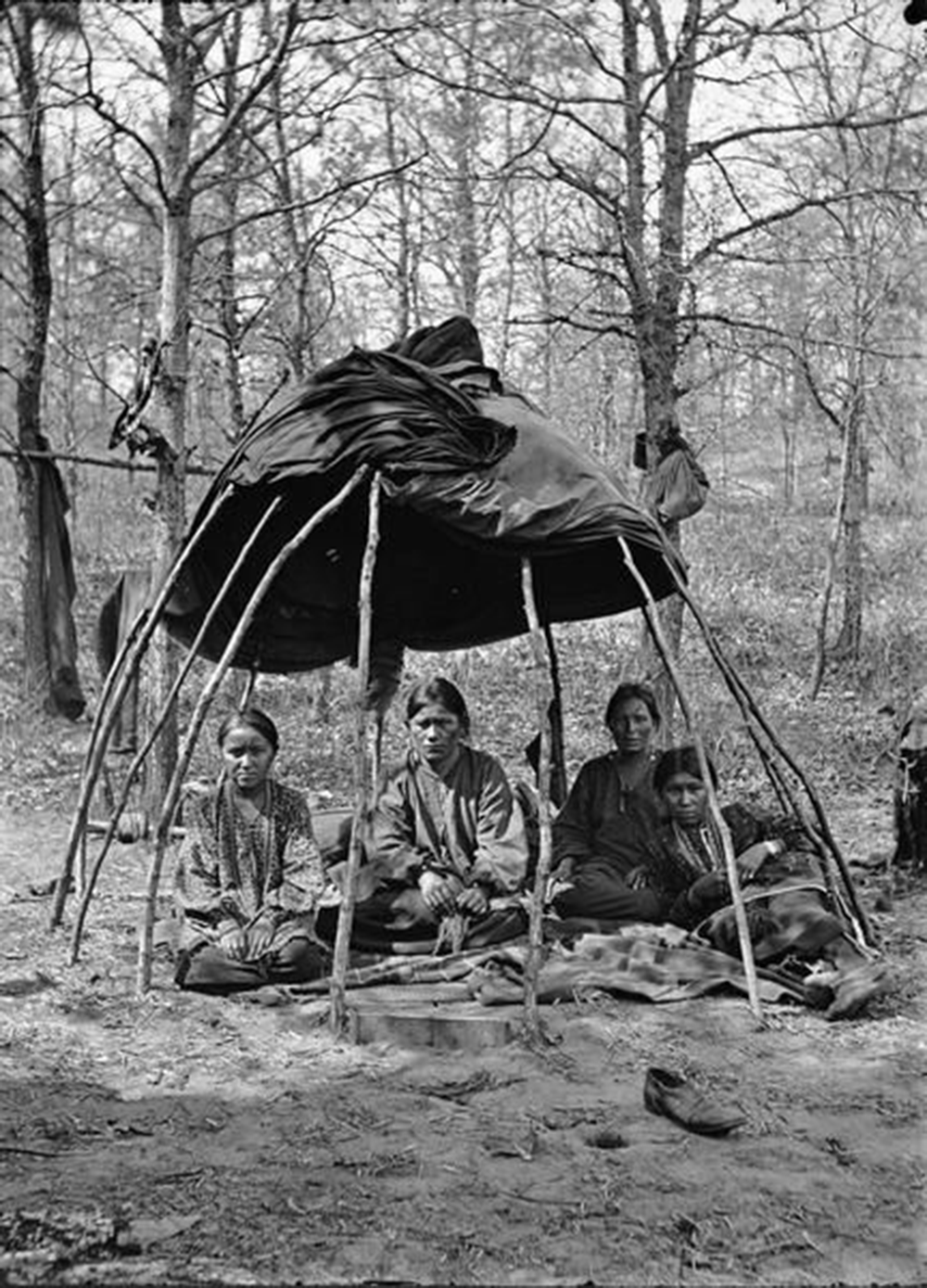 Winnebago women sitting in a chipoteke, a wigwam-like traditional structure. Photograph by Henry Hamilton Bennett. Wisconsin Historical Society.