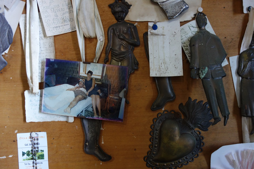 Ex votos, photograph, and notes at the shrine of Uncle Vincent. Photograph by Elizabeth Harper.