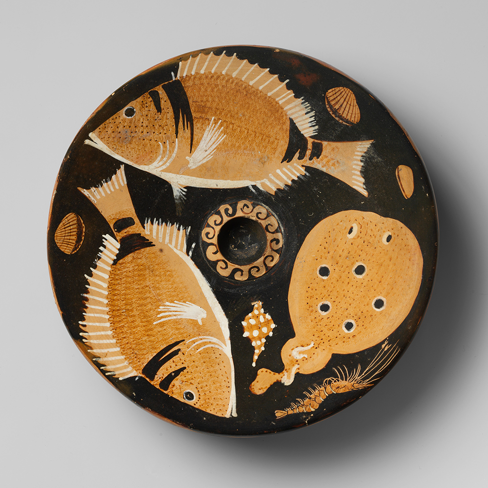 Two bream and a torpedo fish are in the center of this terra-cotta fish plate, with two scallops, a mussel, murex, and shrimp in the background, attributed to the Helgoland Painter, c. 350-325 BC. The Metropolitan Museum of Art, Rogers Fund, 1906.