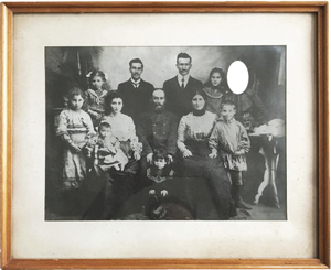A family photograph with one person's face cut out.