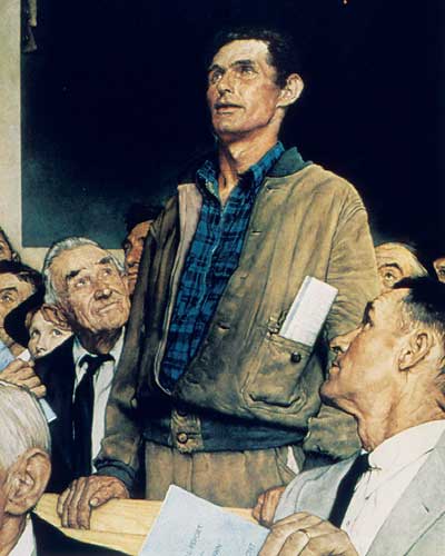 Standing man speaking with seated people looking up at him