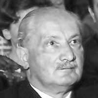 Photograph of a mustached man looking up