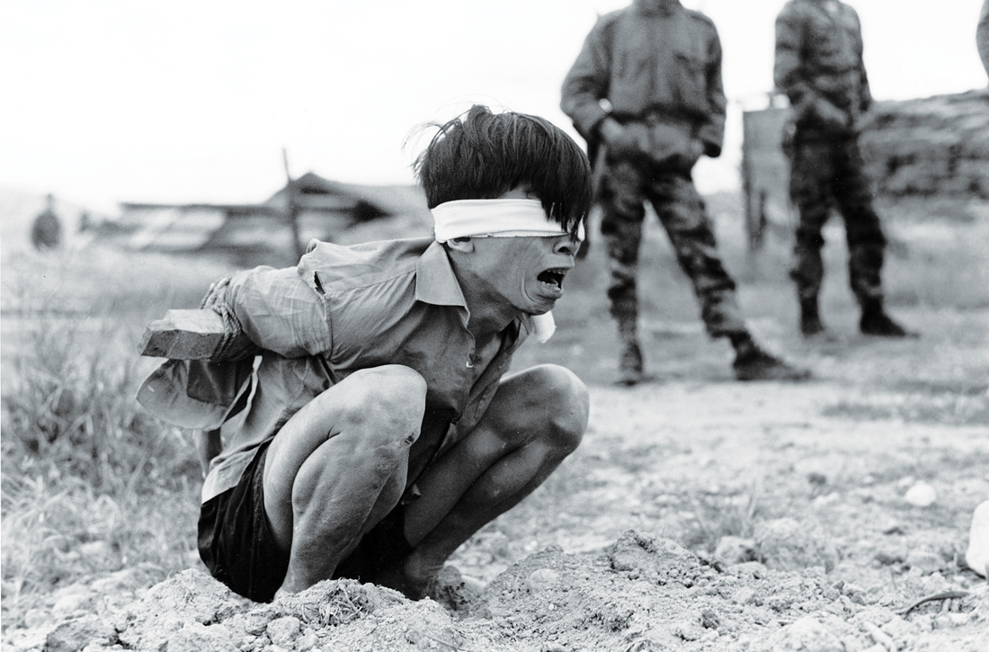 A Vietcong prisoner awaits interrogation at the A-109 Special Forces detachment at Thuong Duc, January 23, 1967. United States National Archives and Records Administration. 