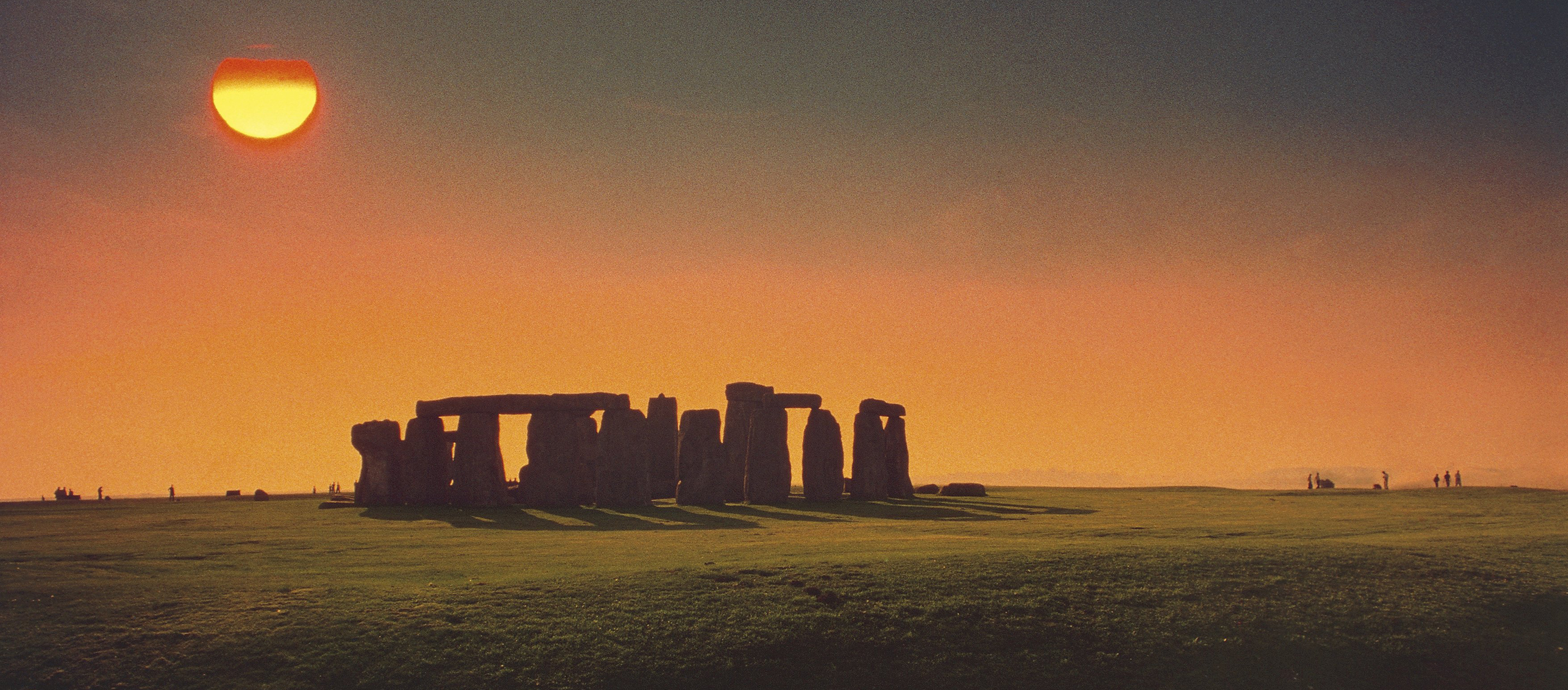 Color photograph of Stonehenge at sunset.