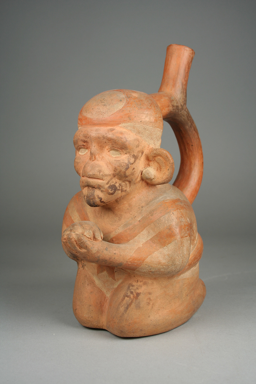 Moche stirrup spout bottle in the form of a kneeling leper, Peru, third to fifth century