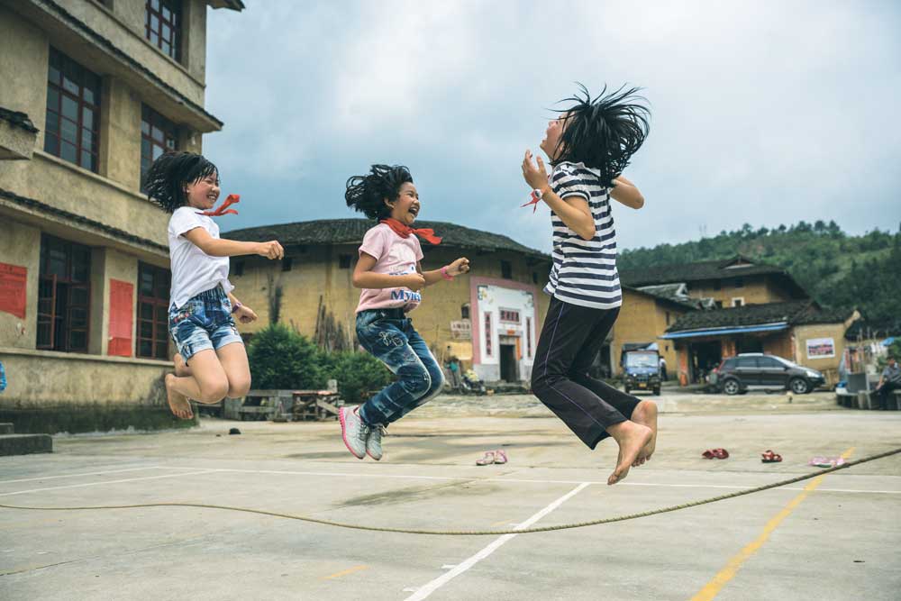 Girls jumping rope at the Chuxi village primary school, Fujian, 2014. Photograph by Michael Yamashita. © Michael Yamashita / GEO Image Collection / Art Resource, NY. Girls jumping rope at the Chuxi village primary school, Fujian, 2014. Photograph by Michael Yamashita.