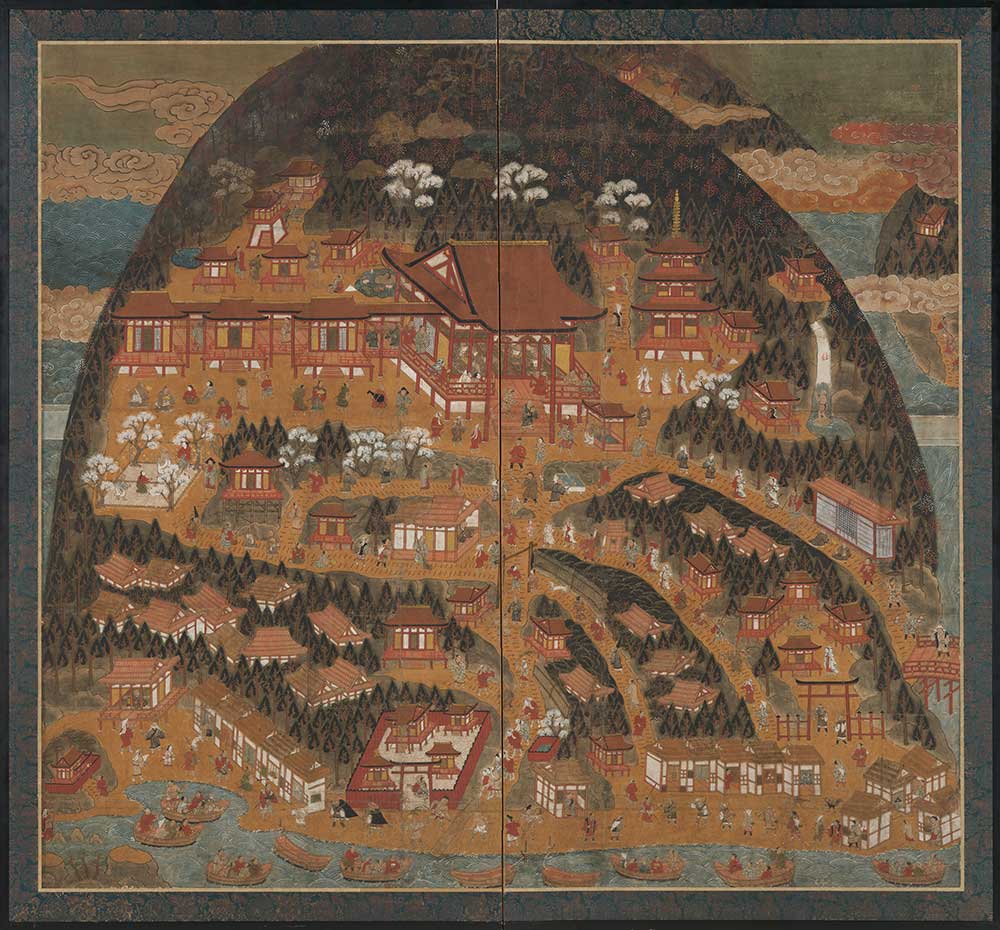 Mountainside temple grounds filled with buildings and activity, with ships in the water at bottom