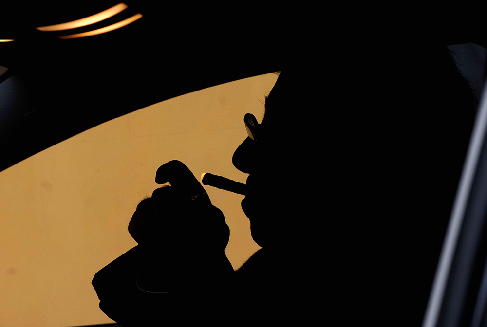 Photograph of Northern League leader Umberto Bossi smoking in his car, by Pier Marco Tacca, 2006.