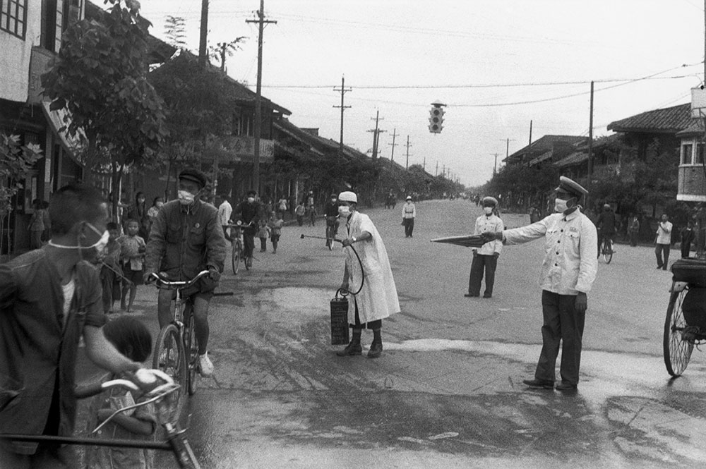 Nurse spraying disinfectant during an epidemic, Chengdu, China, 1958. Photograph by Henri Cartier-Bresson.