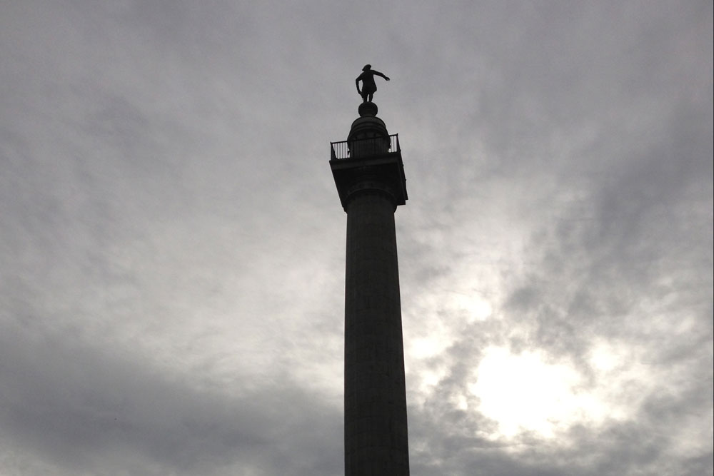 The top of the column of the Trenton Battle Monument, dark against a cloudy sky.