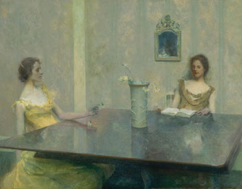 Two women reading at a large table.