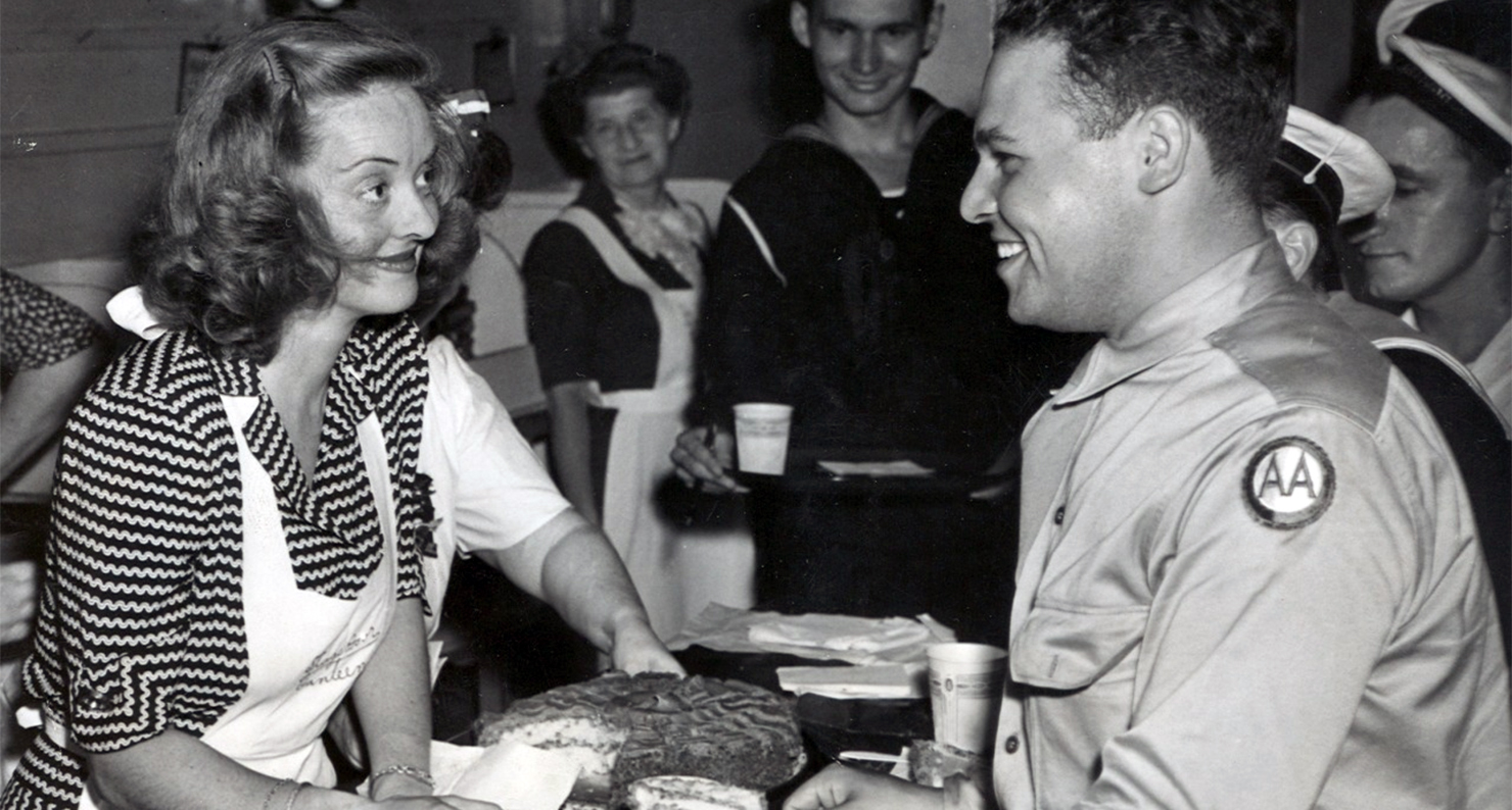 Bette Davis serving food at the Hollywood Canteen.