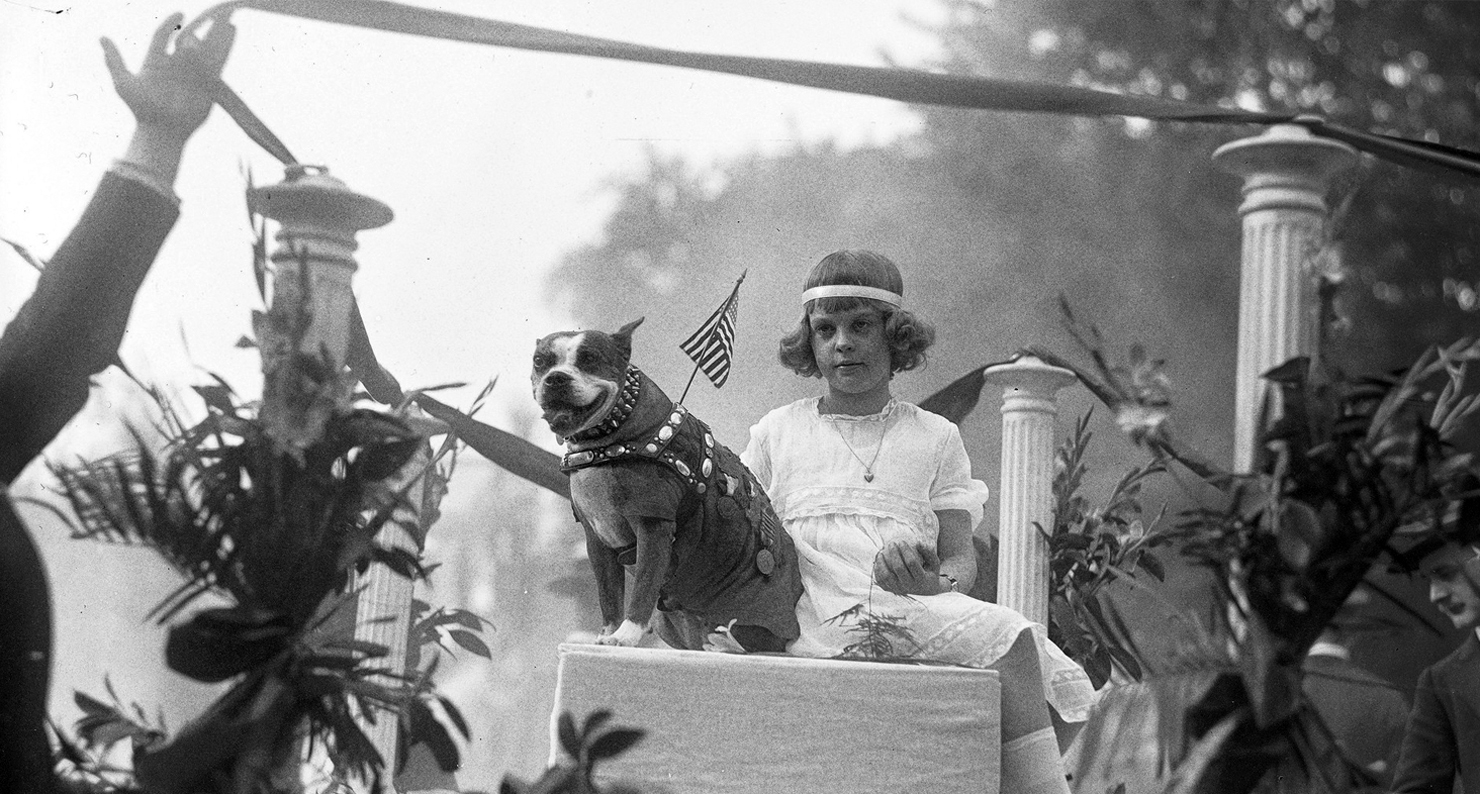 Sgt. Stubby shares a float with Miss Louise Johnson for an animal parade down Washington D.C.'s Pennsylvania Avenue in 1921.
