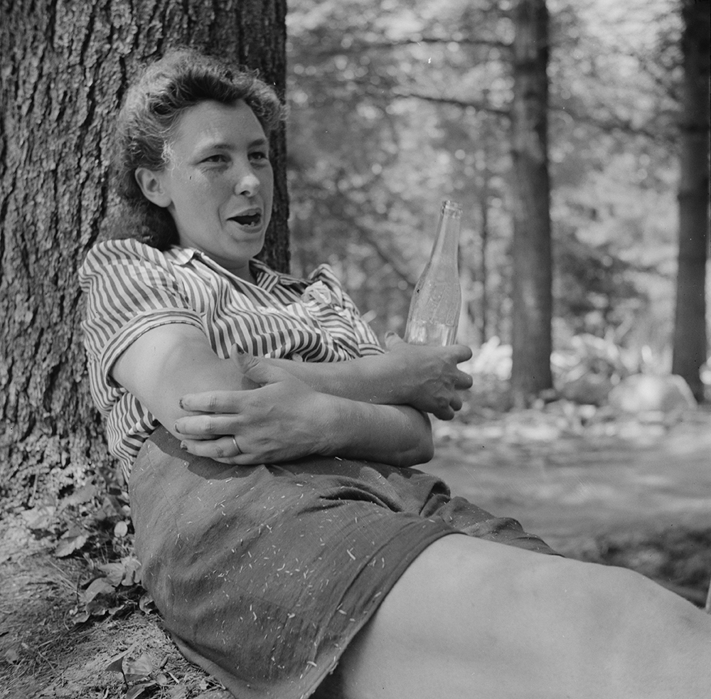 Worker employed by a U.S. Department of Agriculture timber salvage sawmill taking a break, waiting for minor repairs, 1943. Photograph by John Collier Jr.