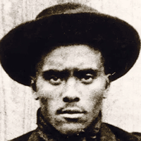 Sepia photograph of a Black man wearing a kerchief and a hat