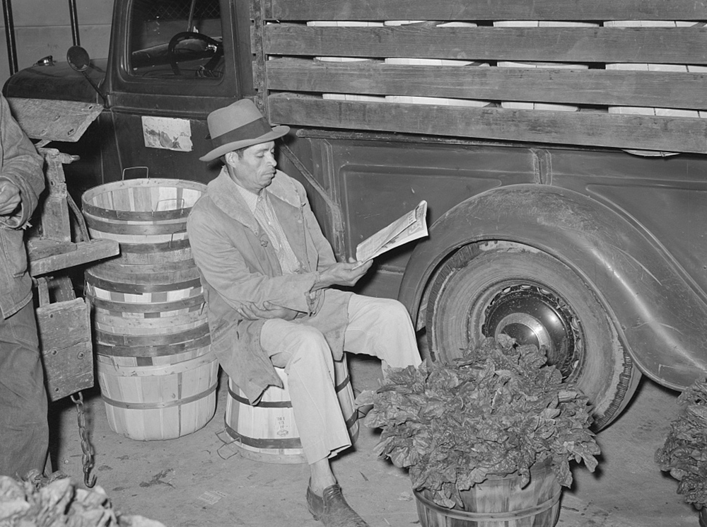 Spinach peddler reading the newspaper in San Antonio, Texas, 1939. Photograph by Russell Lee. Library of Congress, Prints and Photographs Division.