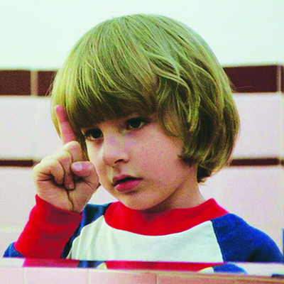 A little boy staring at his bent index finger