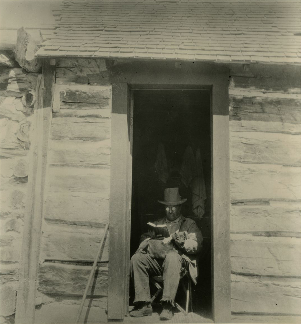 Roosevelt seated in the doorway of the West Divide Creek ranch house. On his lap is a rat terrier named Skip that he found on a trip to the Grand Canyon. Skip would return to the White House and become his son Archie’s. Dickinson State University.