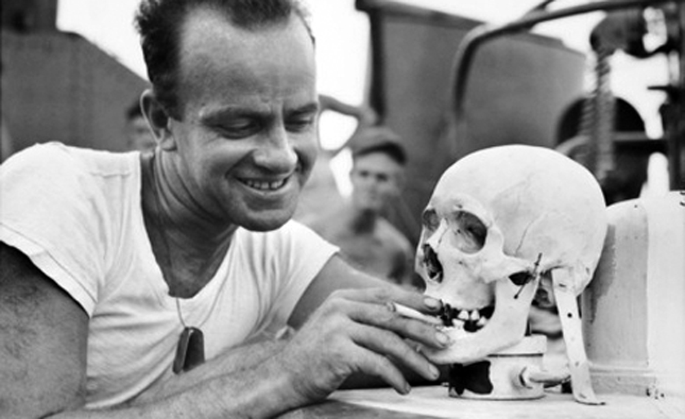 Lieutenant with Japanese skull used as a mascot aboard a Navy torpedo boat, 1944.