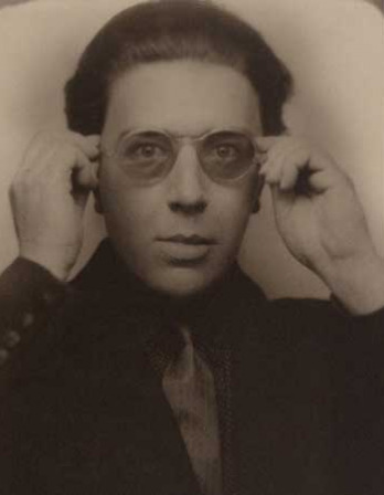 Photograph of a man holding tinted glasses to his face