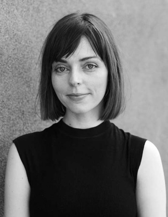 Stephanie DeGooyer Black and white photograph of a woman with chin-length dark hair wearing a sleeveless turtleneck