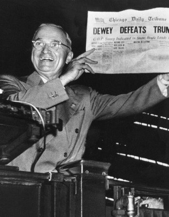 Black and white photo of Harry S. Truman holding a newspaper with the headline "Dewey defeats Truman"