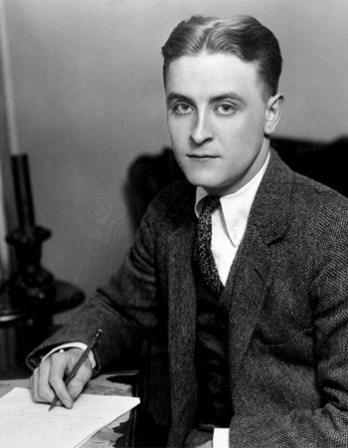 Black and white photograph of a young F. Scott Fitzgerald sitting at a desk.