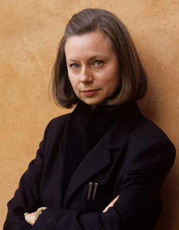 Woman standing against a wall with her arms crossed