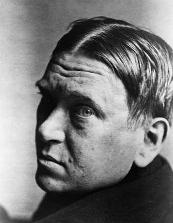 Black and white photograph of Mencken looking over his shoulder at the camera