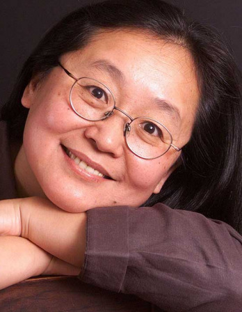 Headshot of woman in glasses resting her head on her crossed arms