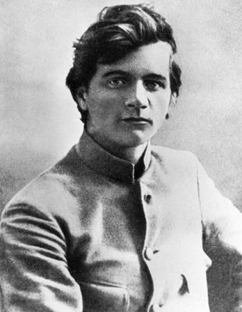 Young man in collarless jacket seated