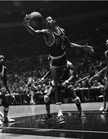 Bill Russell leaps for a basketball while playing for the Celtics.