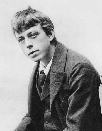 Black-and-white photograph of a young man wearing a coat and tie