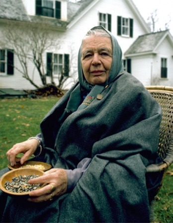 Marguerite Yourcenar Photograph of Marguerite Yourcenar with a headscarf sitting in a chair outside.
