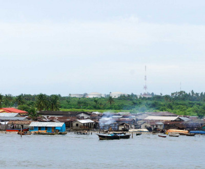 Photograph of a riverbank with shanties.