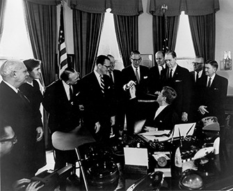 President John F. Kennedy hands Senator Estes Kefauver the pen he used to sign the 1962 Amendments to the Federal Food, Drug and Cosmetic Act. Wikimedia Commons, U.S. Food and Drug Administration.