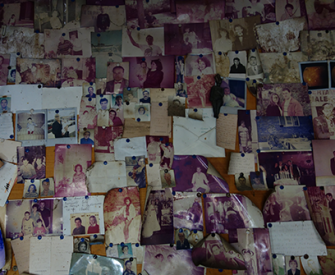 Photographs left by those who have prayed to Uncle Vincent. Photograph by Elizabeth Harper.