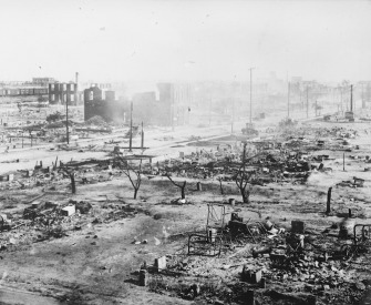 A photograph of the ruins of the Tulsa Race Massacre, showing the rubble of burned homes and businesses.
