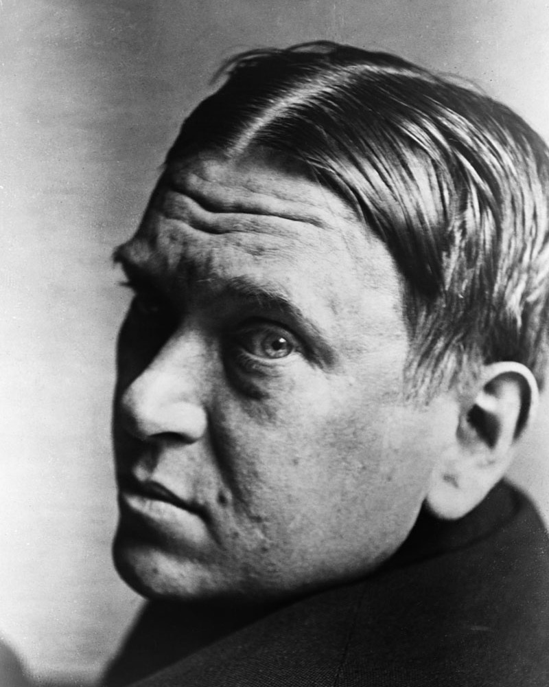 Black and white photograph of Mencken looking over his shoulder at the camera