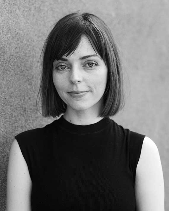 Black and white photograph of a woman with chin-length dark hair wearing a sleeveless turtleneck