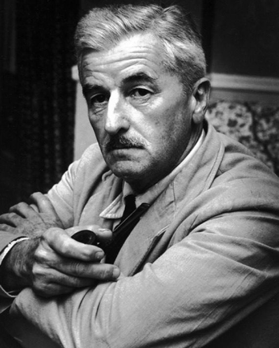 Photograph of William Faulkner sitting in a chair.