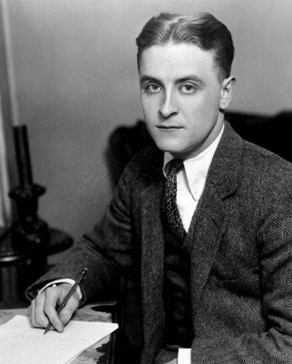 Black and white photograph of a young F. Scott Fitzgerald sitting at a desk.