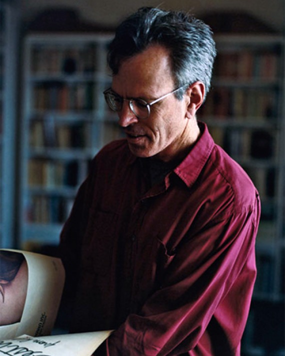 Photograph of Jim Holt looking at a book.