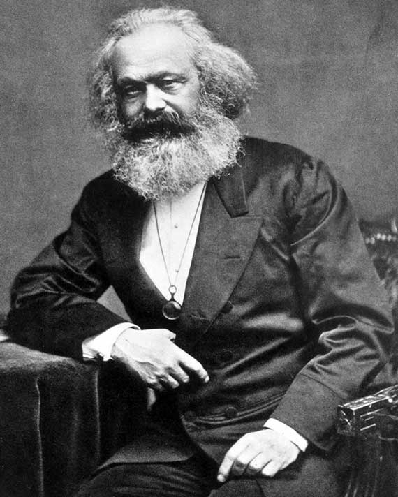 Karl Marx Seated man with a large white beard wearing a dark suit