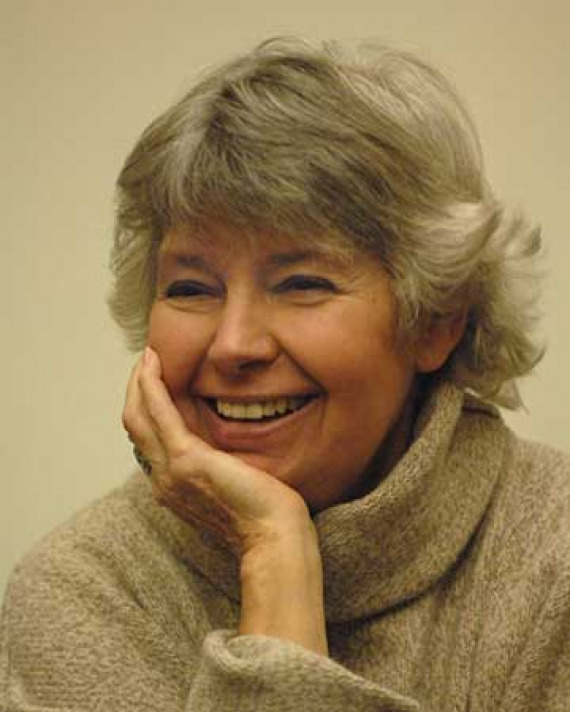 Robin Morgan Photograph of a smiling gray-haired woman resting her chin in her right hand