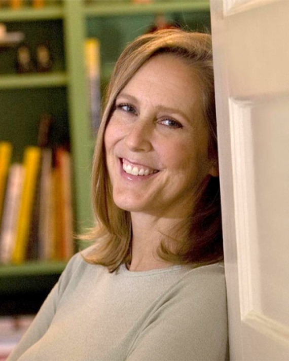 Color photograph of American writer Mary Roach leaning on door.